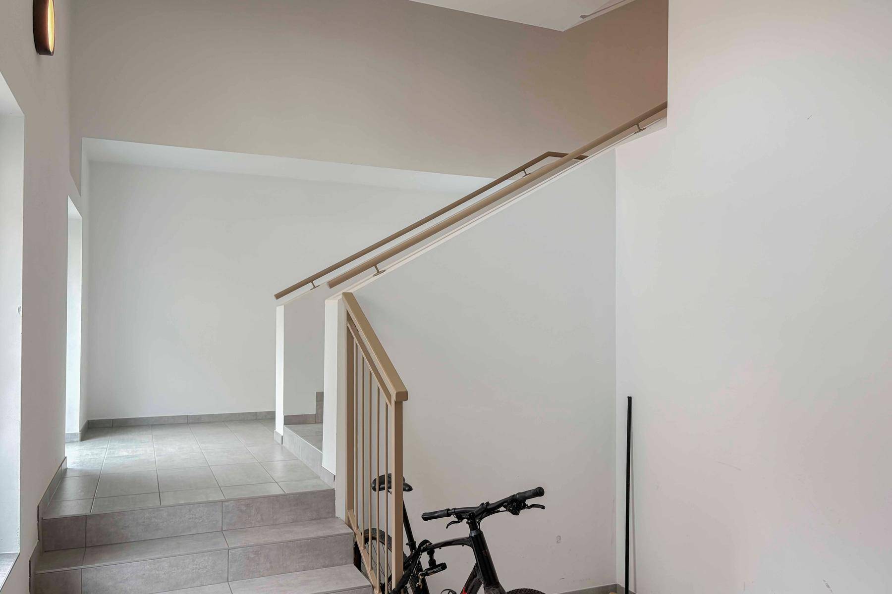Geräumiger Treppenabsatz mit Fliesenboden und Fahrradabstellmöglichkeit.