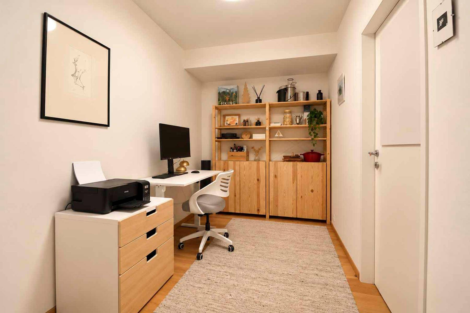 Funktionales Heimbüro mit Holzregalen, Schreibtisch und Drucker, ideal für konzentriertes Arbeiten.