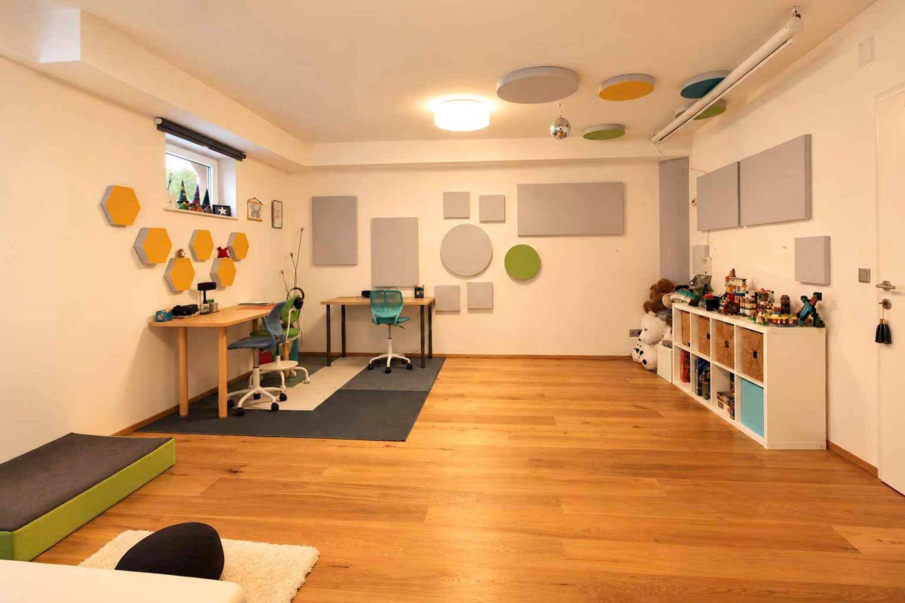 Geräumiger Hobbyraum im Keller mit Holzboden, Spielbereich und kreativer Wandgestaltung.