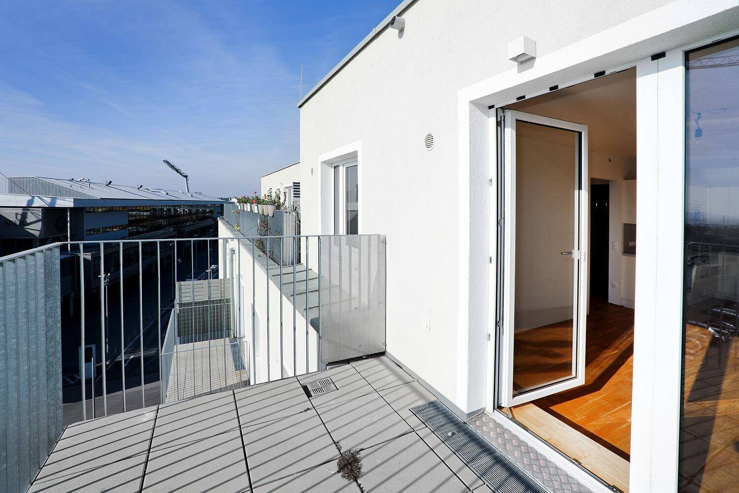 Geräumige Terrasse mit Zugang zum Innenraum und Blick auf die umliegende Bebauung.
