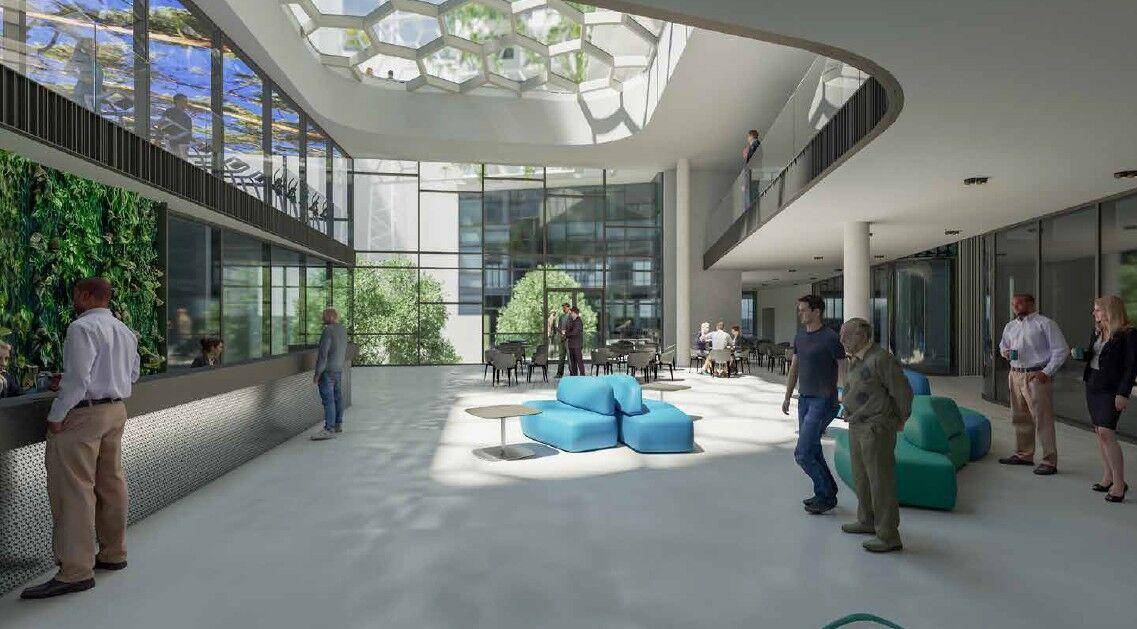 Helle, moderne Lobby mit großen Glasfronten, Sitzbereichen und vertikalen Gärten an den Wänden.