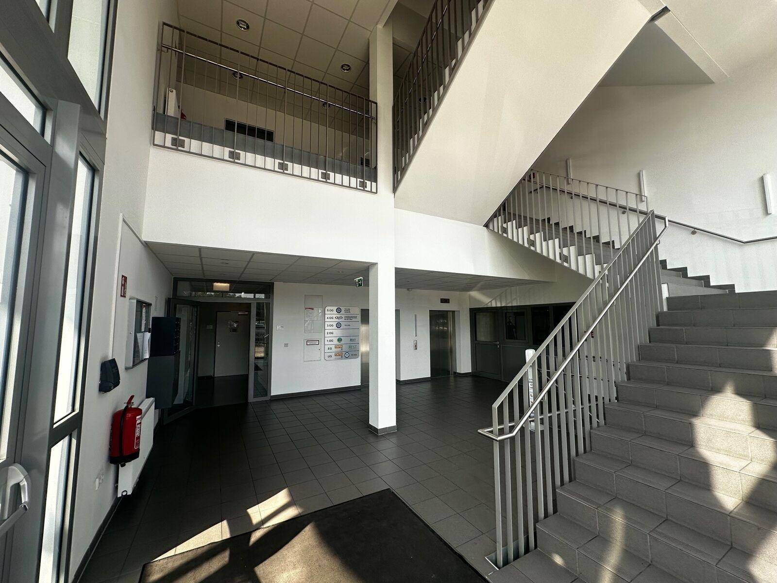Geräumiger Eingangsbereich mit Treppe, Fliesenboden und hohen Decken, in gutem Zustand.