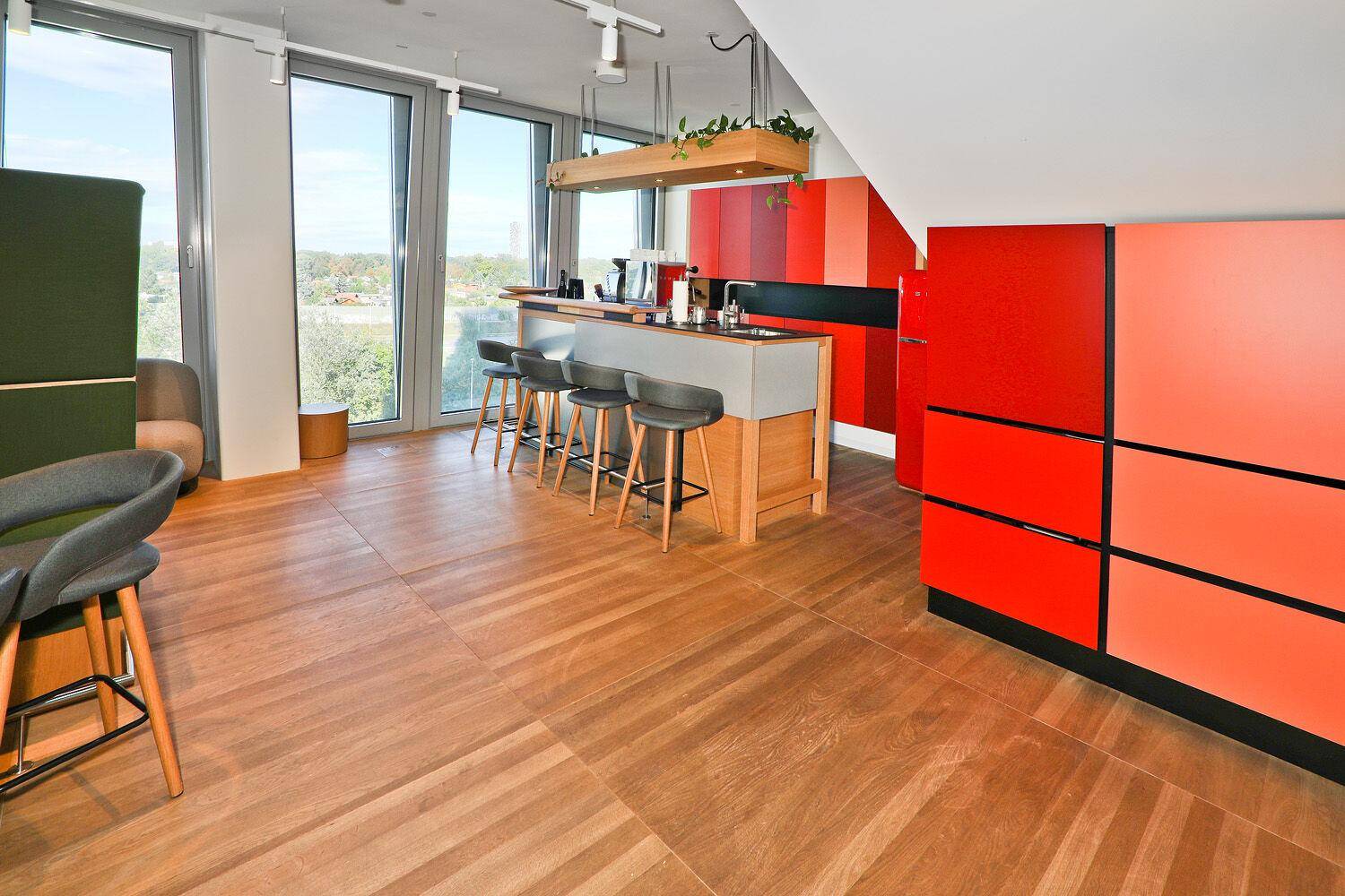 Gemütlicher Loungebereich mit Bar, Holzboden und farbenfrohen Akzentwänden, ideal für Pausen.