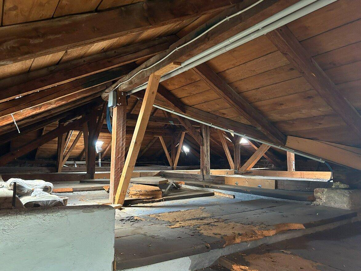 Dachboden mit sichtbaren Holzbalken und der Dachkonstruktion, bietet Ausbaupotenzial.