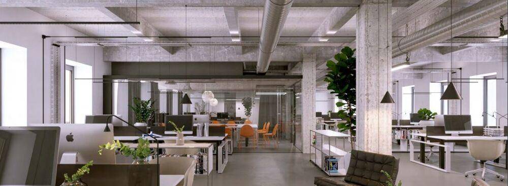 Geräumiges Büro mit industriellem Charme, Sichtbeton und modernen Arbeitsplätzen.