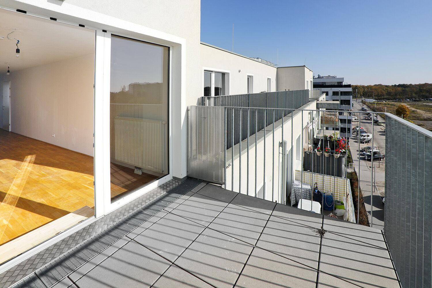 Große, sonnige Terrasse mit Blick auf die Umgebung und angrenzende Gebäude.
