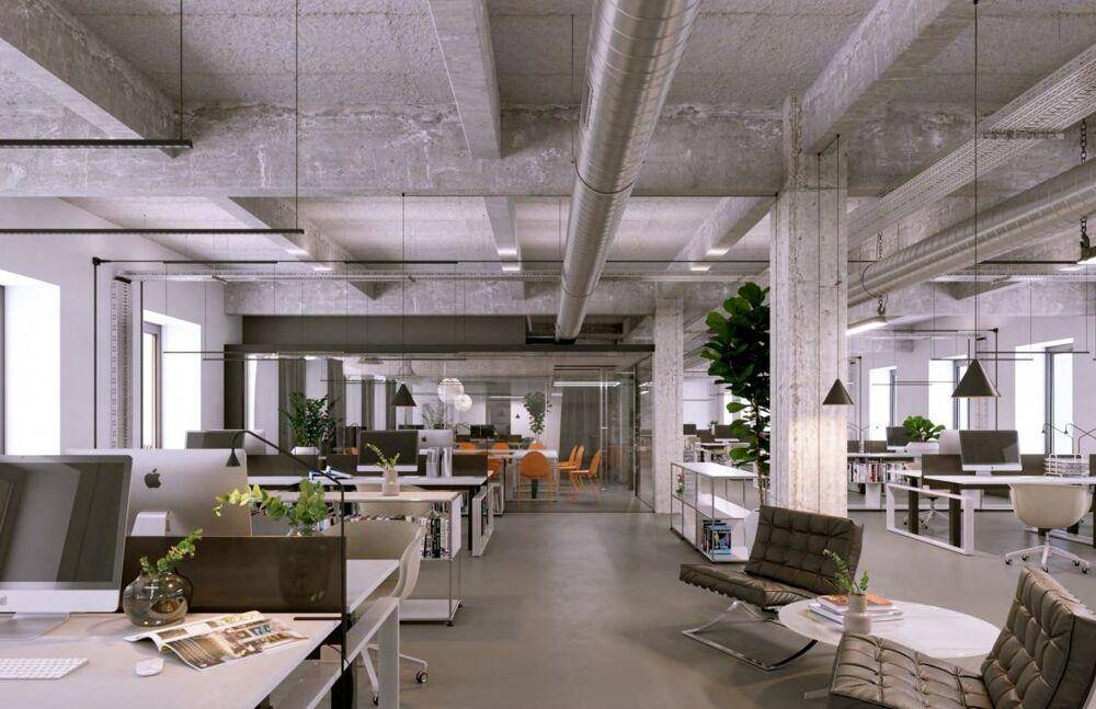 Helles und offenes Büro mit Sichtbeton, großen Fenstern und modernen Büromöbeln.