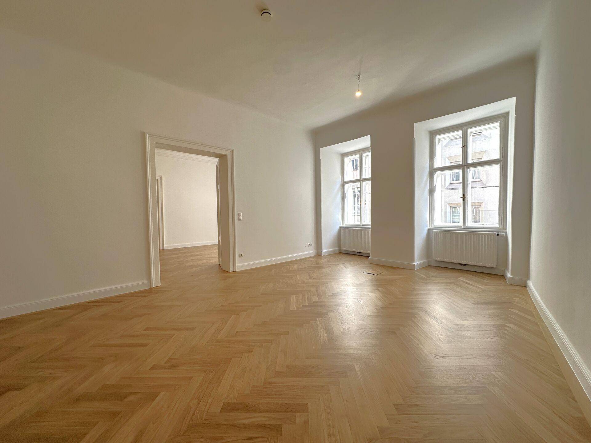 Zimmer mit beeindruckender Gewölbedecke, Fischgrätparkett und viel Tageslicht.