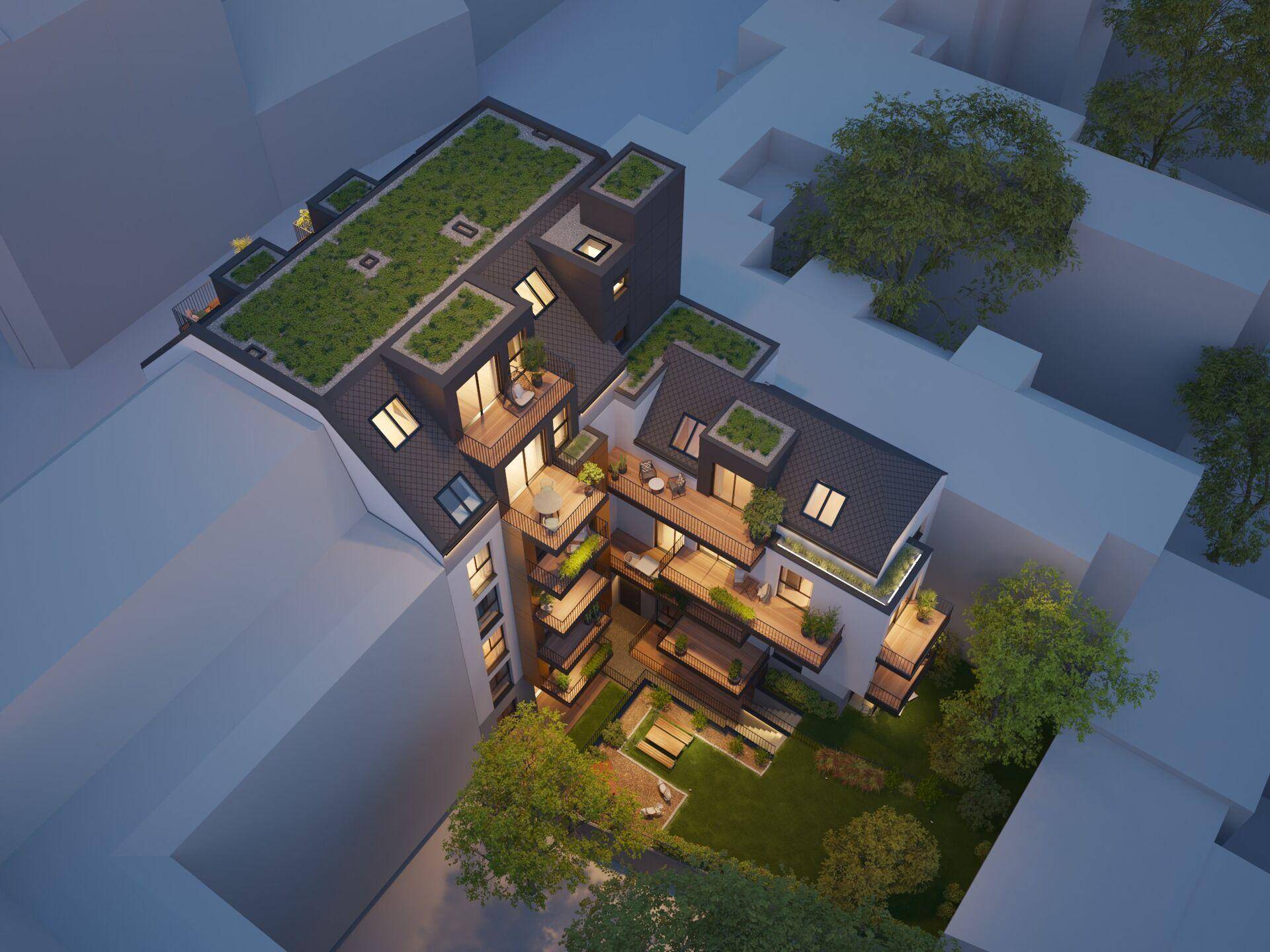 Vogelperspektive der Wohnanlage bei Nacht mit beleuchteten Innenhöfen und begrünten Dächern.