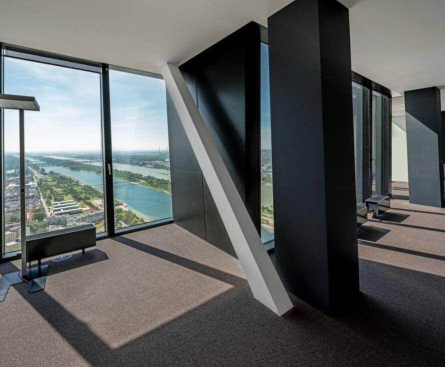 Bürofläche in einem Hochhaus mit raumhohen Fenstern, die einen weiten Blick auf den Fluss bieten.