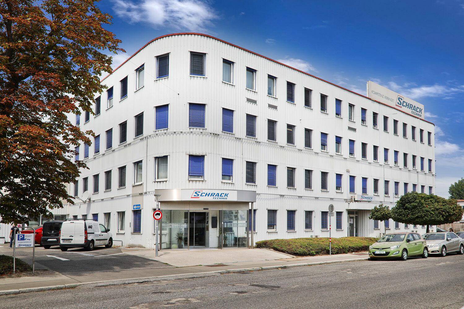 Hauptansicht des modernen Bürogebäudes mit Haupteingang und gepflegter Umgebung.