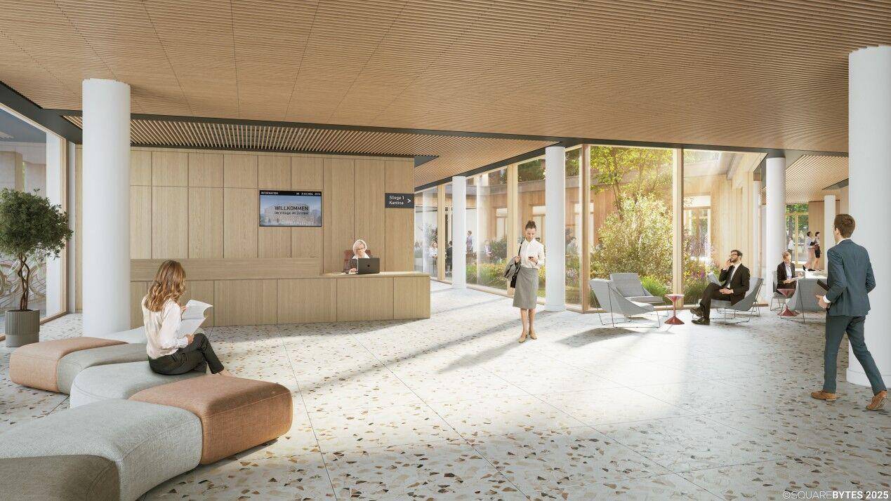 Geräumige und helle Lobby mit Rezeption, Sitzgelegenheiten und großen Glasfronten zum Innenhof.