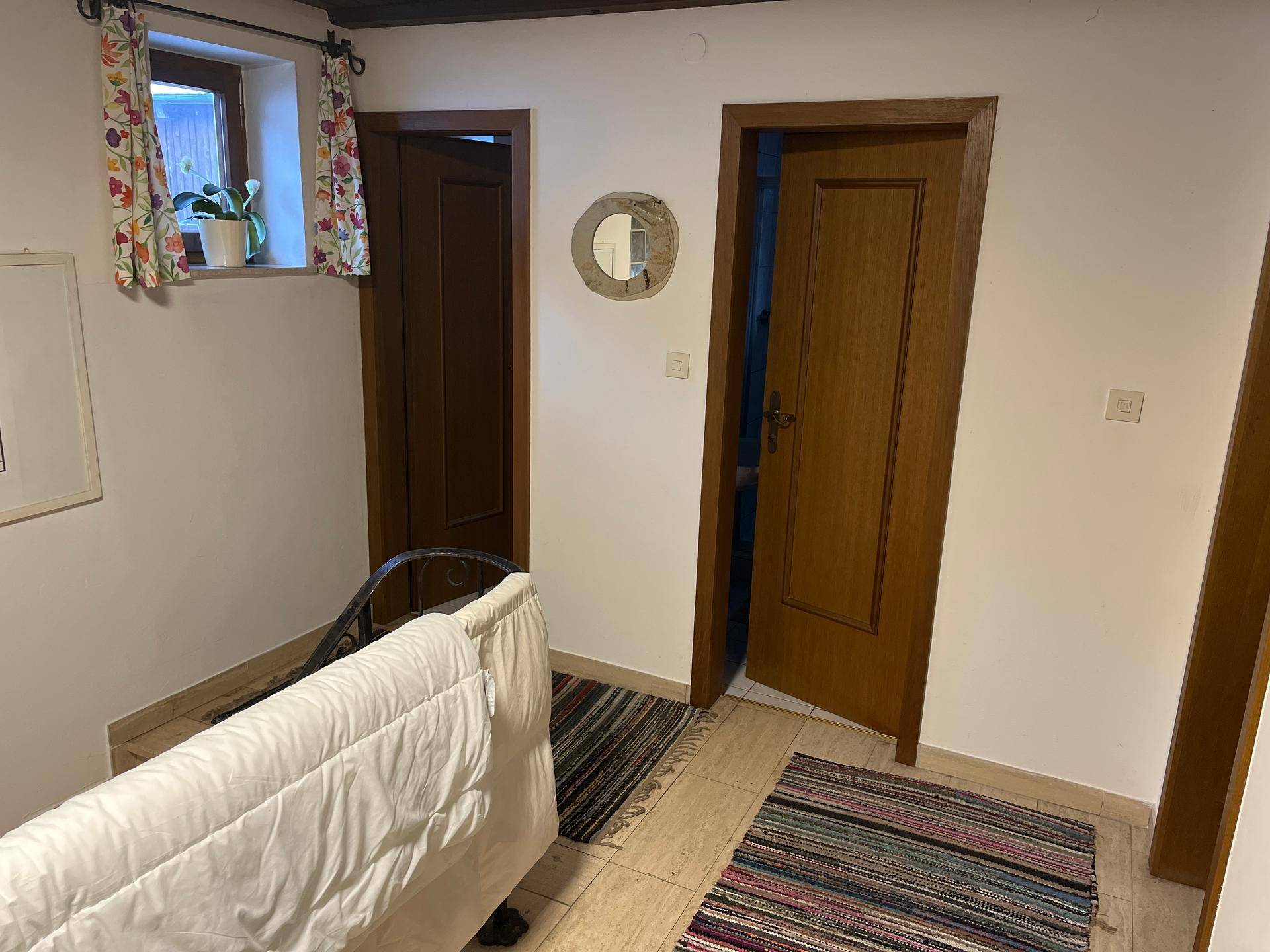 Flur mit mehreren Holztüren und gemusterten Teppichen, der zu weiteren Räumen führt.