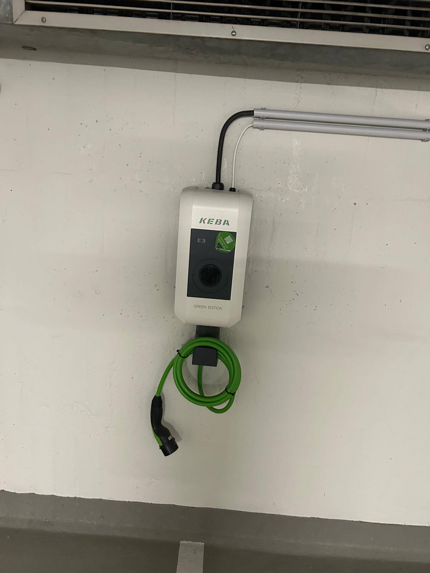 Nahaufnahme einer modernen KEBA Ladestation für Elektrofahrzeuge in der Tiefgarage.