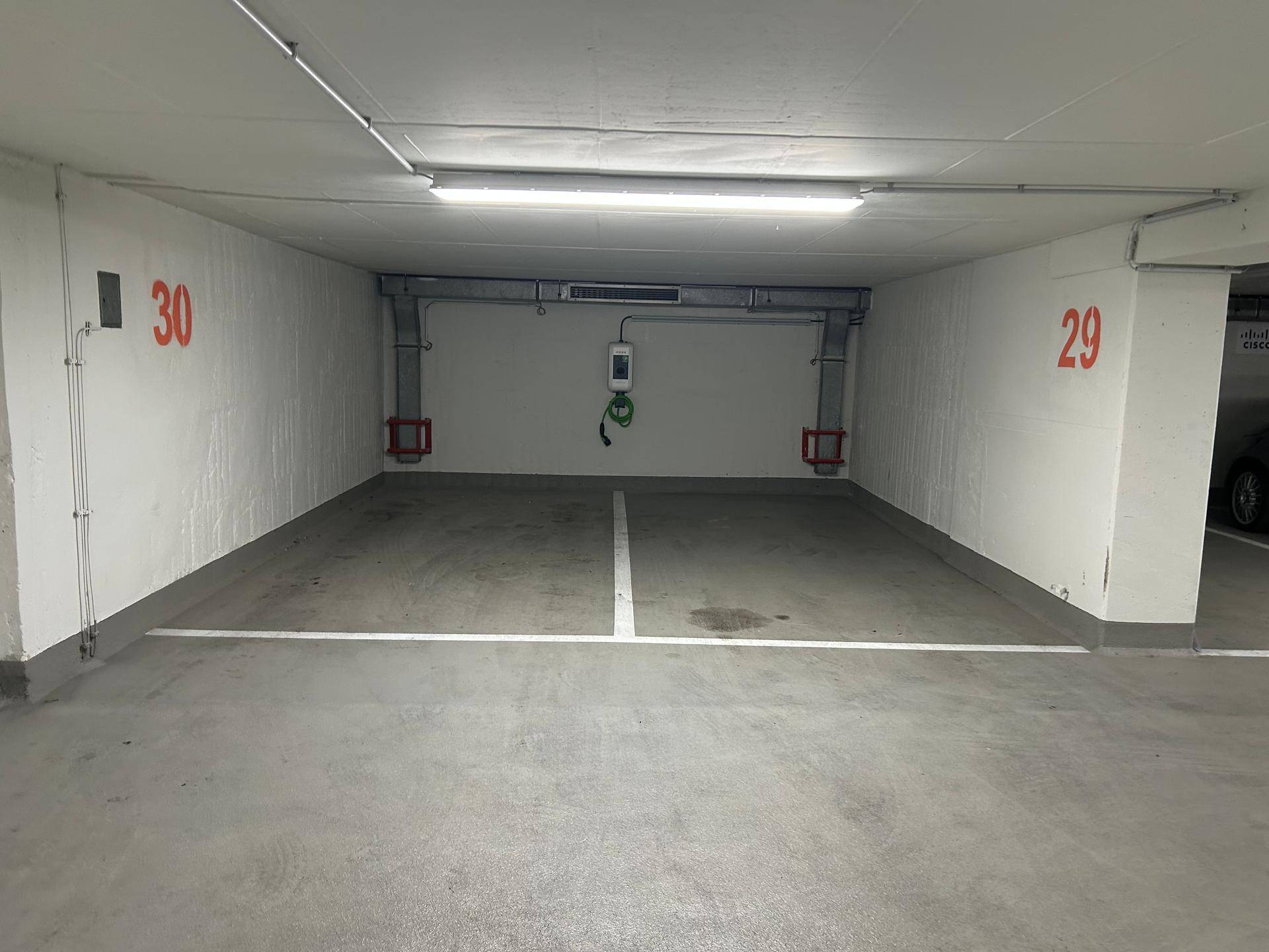 Geräumiger Tiefgaragenstellplatz mit integrierter Lademöglichkeit für Elektrofahrzeuge.