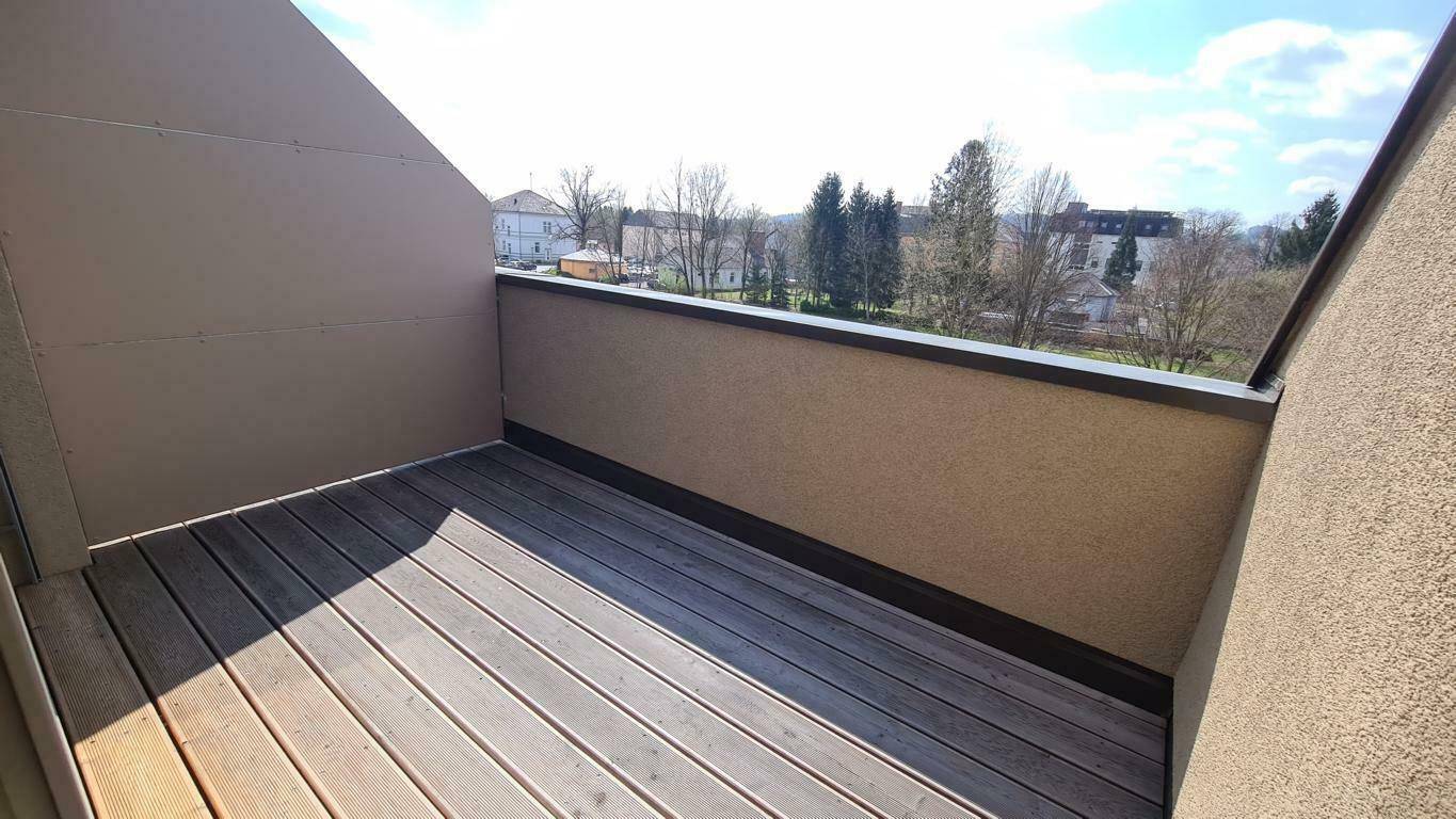 Leere Dachterrasse mit Holzboden und weitem Blick über die Landschaft.