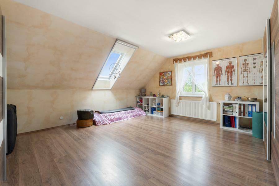 Helles Schlafzimmer im Dachgeschoss mit Dachschräge, Dachfenster und Laminatboden.