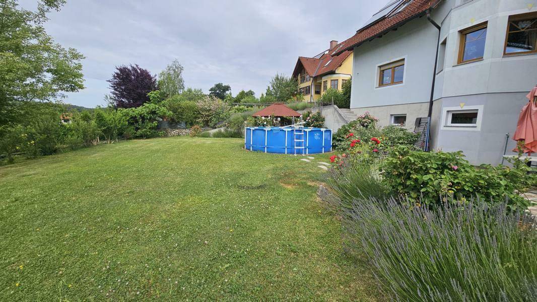 Blühender Lavendel im Vordergrund mit Blick auf den Rasen, Aufstellpool und die umliegende Landschaft.