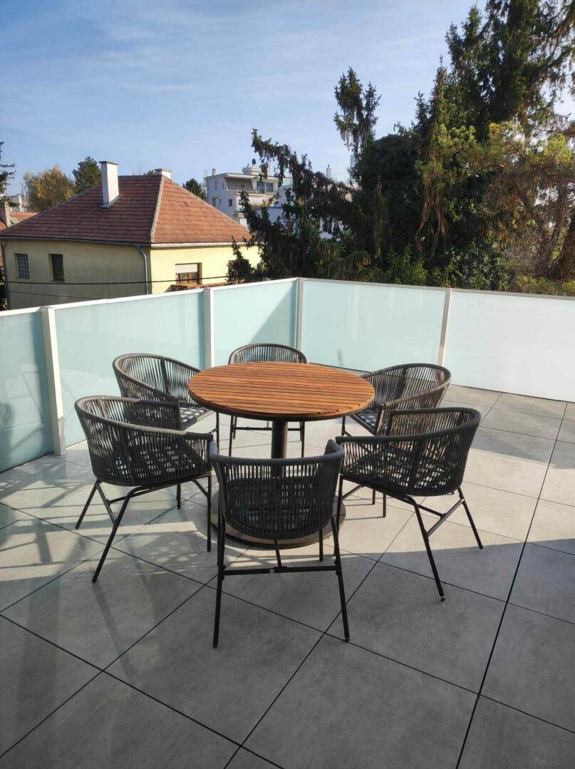 Geräumige Dachterrasse mit modernen Gartenmöbeln und weitem Blick.