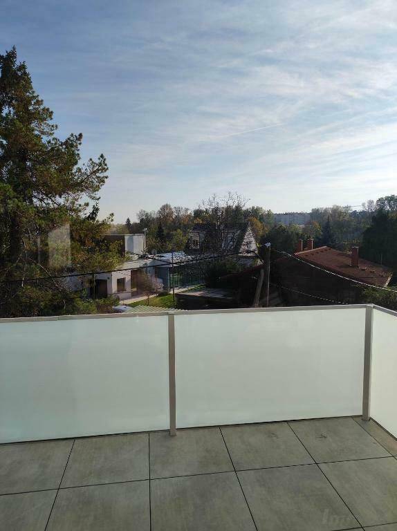 Weitläufige Terrasse mit Blick auf die umliegende Wohngegend und viel Grün.
