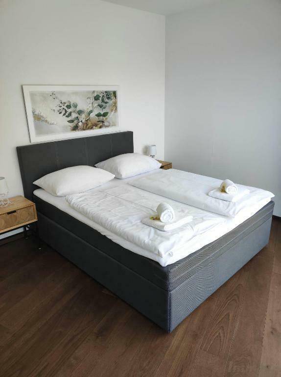 Helles Schlafzimmer mit Doppelbett, Holzboden und schlichter, moderner Einrichtung.