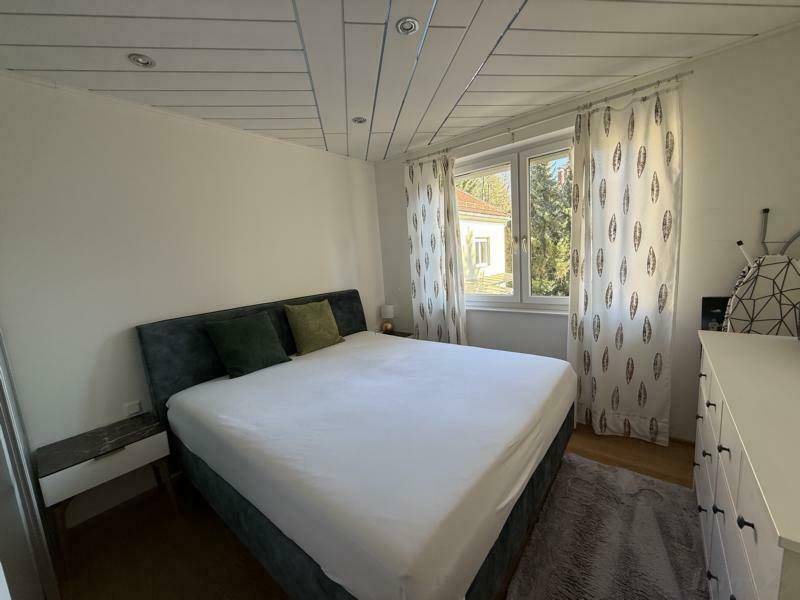 Schlafzimmer mit großem Fenster, das viel Tageslicht hereinlässt und einen Blick ins Grüne bietet, für eine entspannte Atmosphäre.