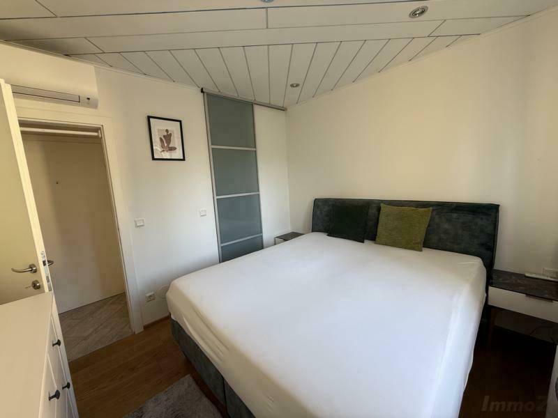 Helles Schlafzimmer mit komfortablem Doppelbett und Klimaanlage, ideal für erholsamen Schlaf in angenehmer Temperatur.