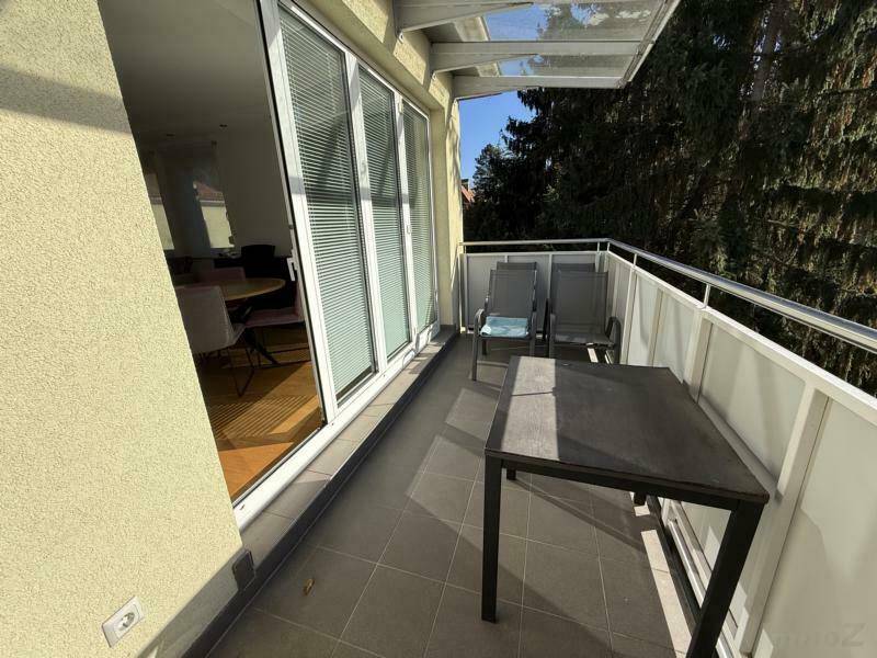 Kleiner Balkon mit Sitzgelegenheiten und Blick ins Grüne, perfekt für eine Tasse Kaffee am Morgen.