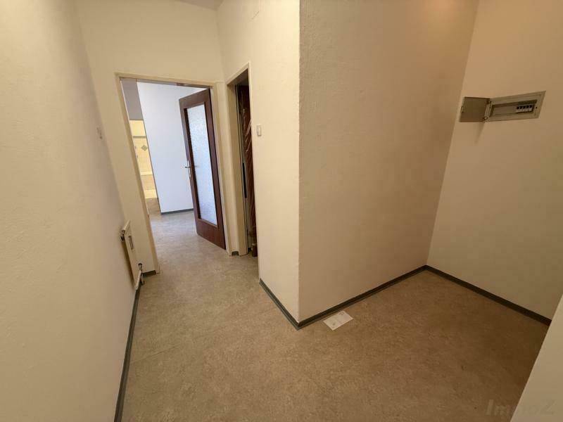 Flur mit hellem Boden und Zugang zu verschiedenen Räumen.