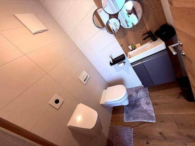 Kleines Gäste-WC im Dachgeschoss mit modernem Waschtisch und Wand-WC.