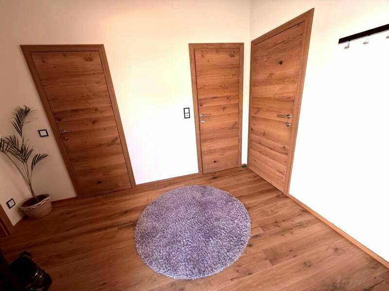 Heller Flur im Dachgeschoss mit Holzboden und mehreren Holztüren.