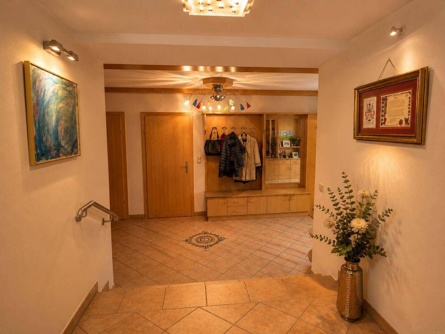 Freundlicher Flur mit Garderobe, Fliesenboden und Zugang zu weiteren Räumen.