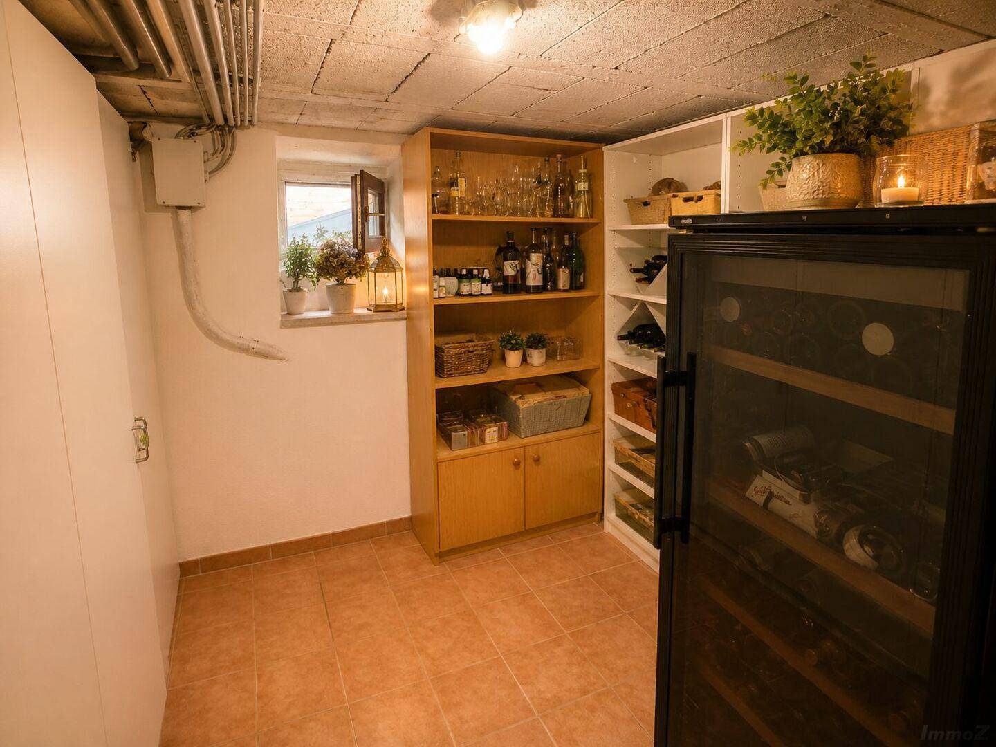Gut ausgestatteter Kellerraum mit Weinregalen, Weinkühlschrank und Fliesenboden.