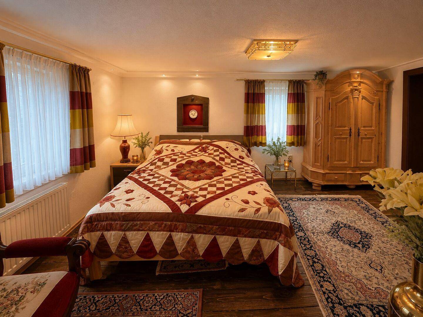 Geräumiges Schlafzimmer mit großem Bett, Holzfußboden und traditionellem Kleiderschrank.