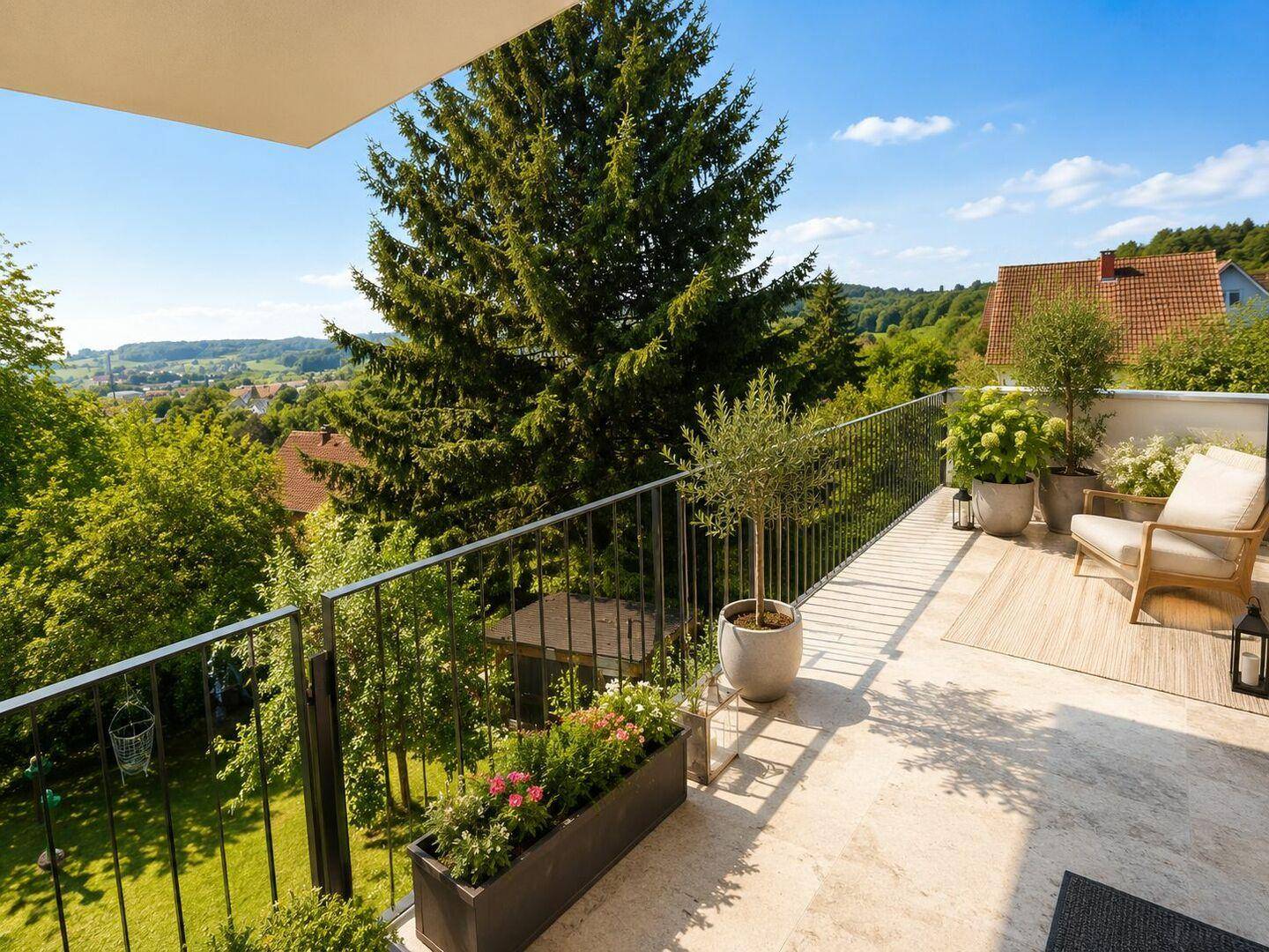 Großer Balkon mit Sitzgelegenheiten und weitem Blick über die grüne Landschaft.