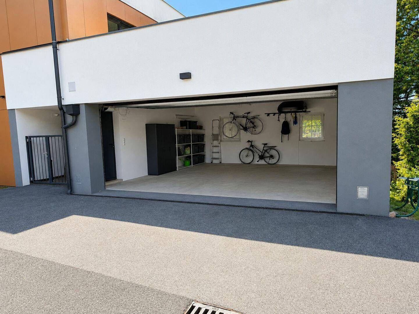 Geräumige Garage mit Platz für zwei Fahrzeuge und Fahrradaufhängungen.