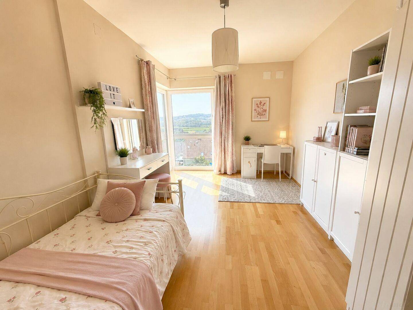 Freundliches Schlafzimmer mit Holzboden, Schminktisch und Zugang zu einem kleinen Balkon.