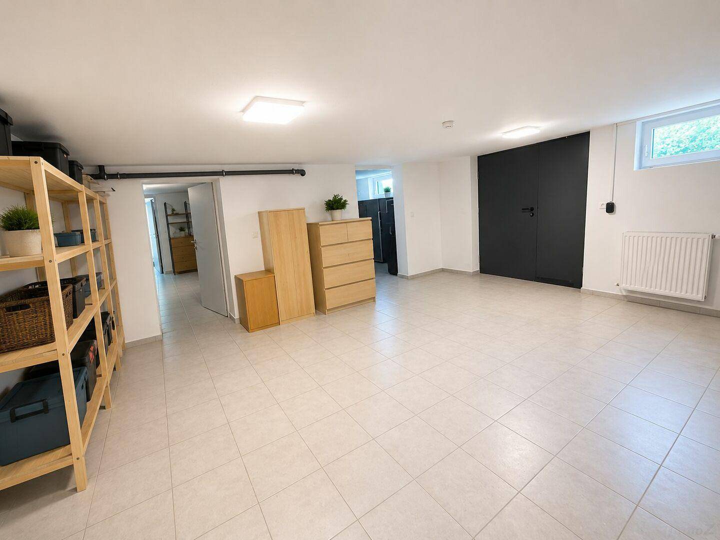 Geräumiger Kellerraum mit Fliesenboden, Fenster und vielseitigen Nutzungsmöglichkeiten.