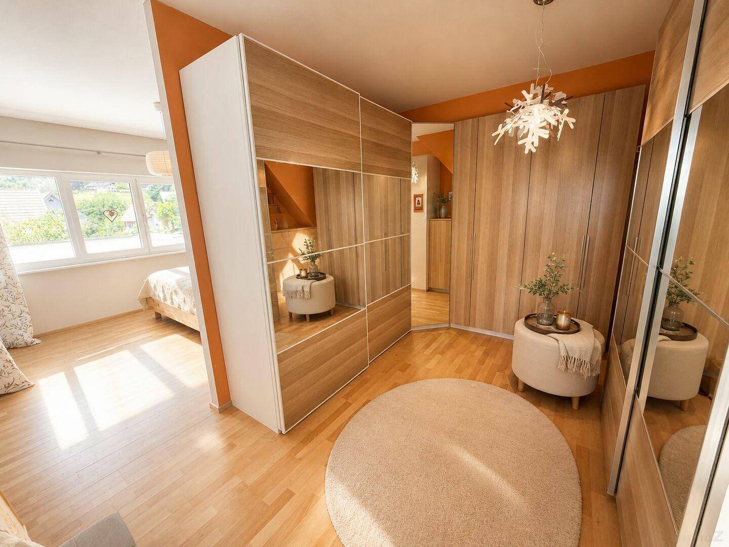 Geräumiges Schlafzimmer mit Holzboden und integrierten Spiegelschränken für viel Stauraum.