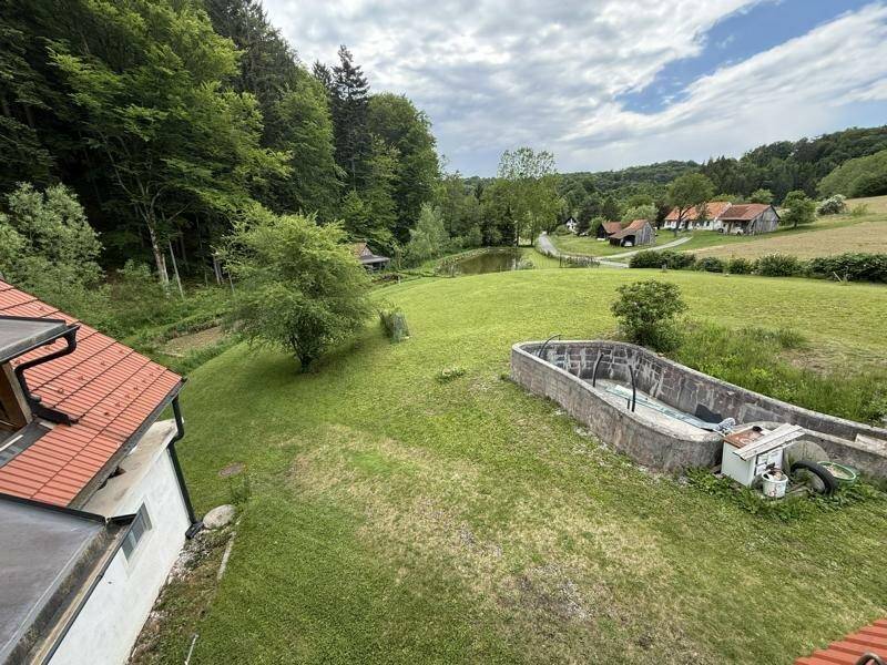Weitläufiger Blick über das Anwesen mit Grünflächen und umliegender Natur, idyllische Lage.