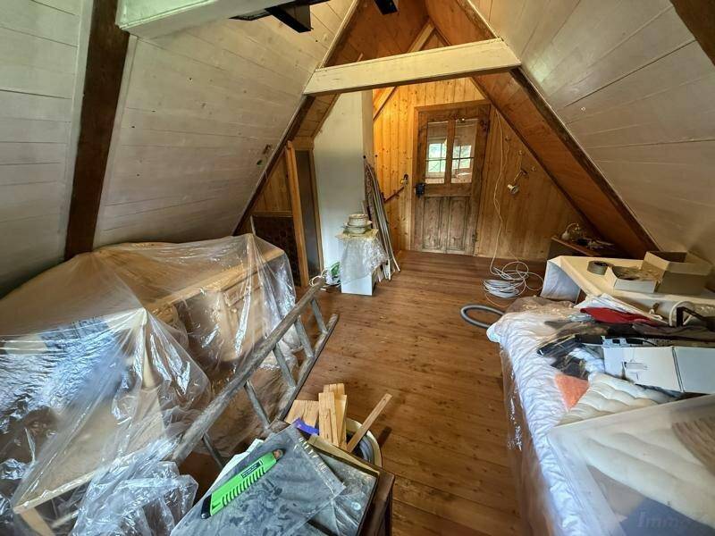 Dachgeschossraum mit Holzboden und schrägen Wänden, bereit für den Ausbau und individuelle Gestaltung.