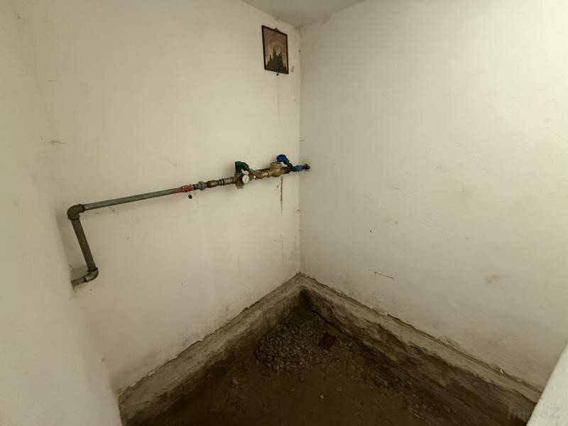 Kleiner Kellerraum mit freiliegenden Rohren und unfertigem Bodenbereich, bereit für Ausbau.