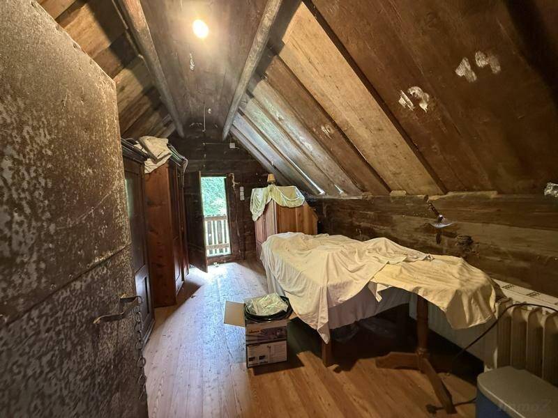 Dachgeschossraum mit Holzböden und schrägen Decken, derzeit als Abstellraum genutzt, mit Ausblick.