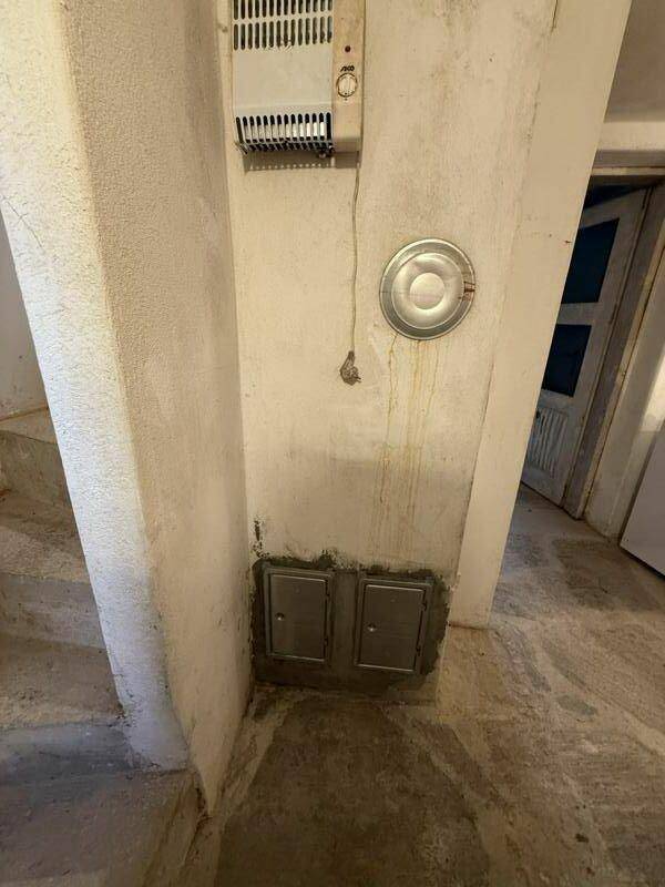 Flurbereich im Untergeschoss mit Heizungsinstallation und Zugang zu weiteren Räumen.