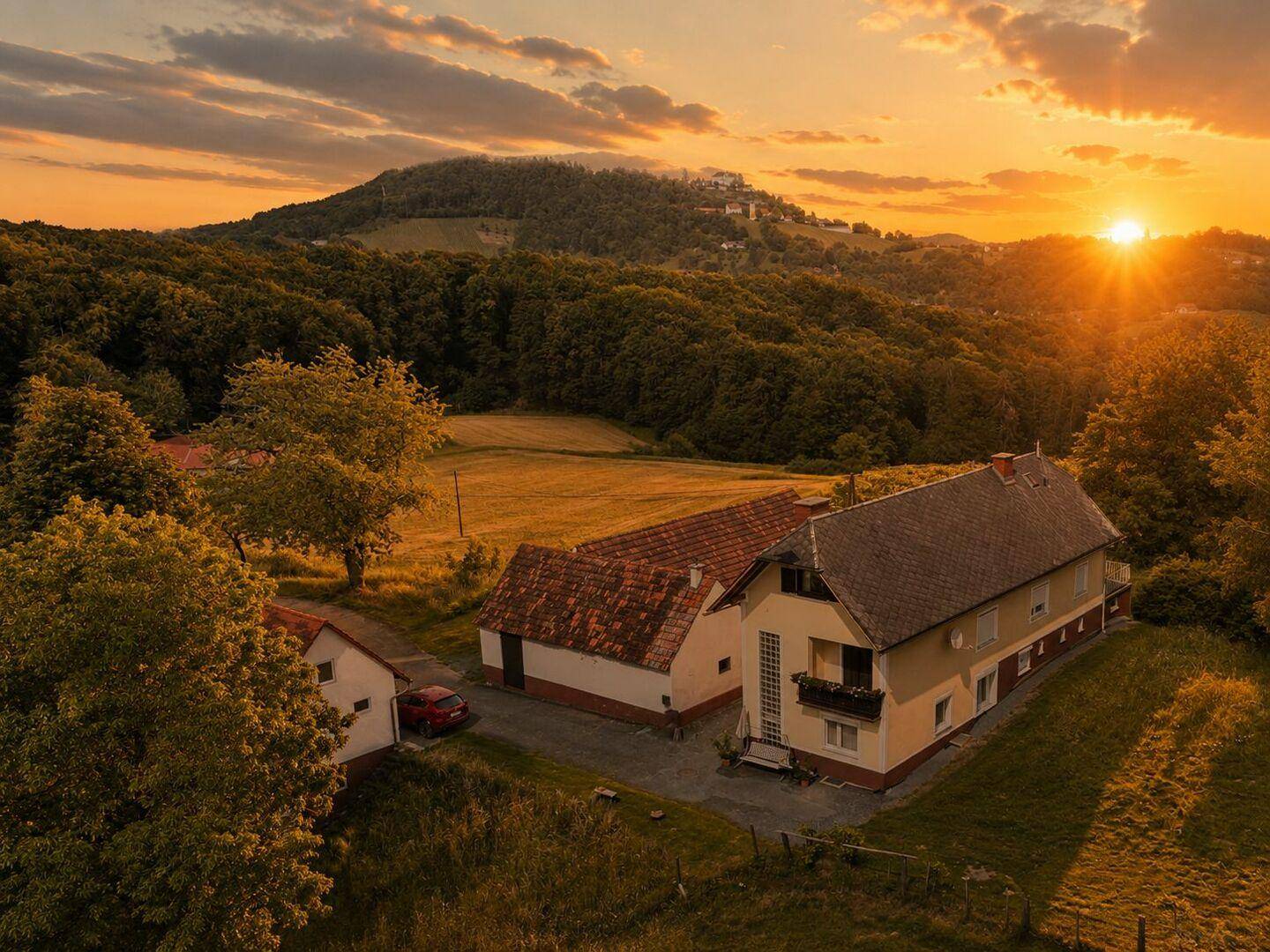 Luftaufnahme von mehreren Häusern in einer ländlichen Umgebung bei Sonnenuntergang.