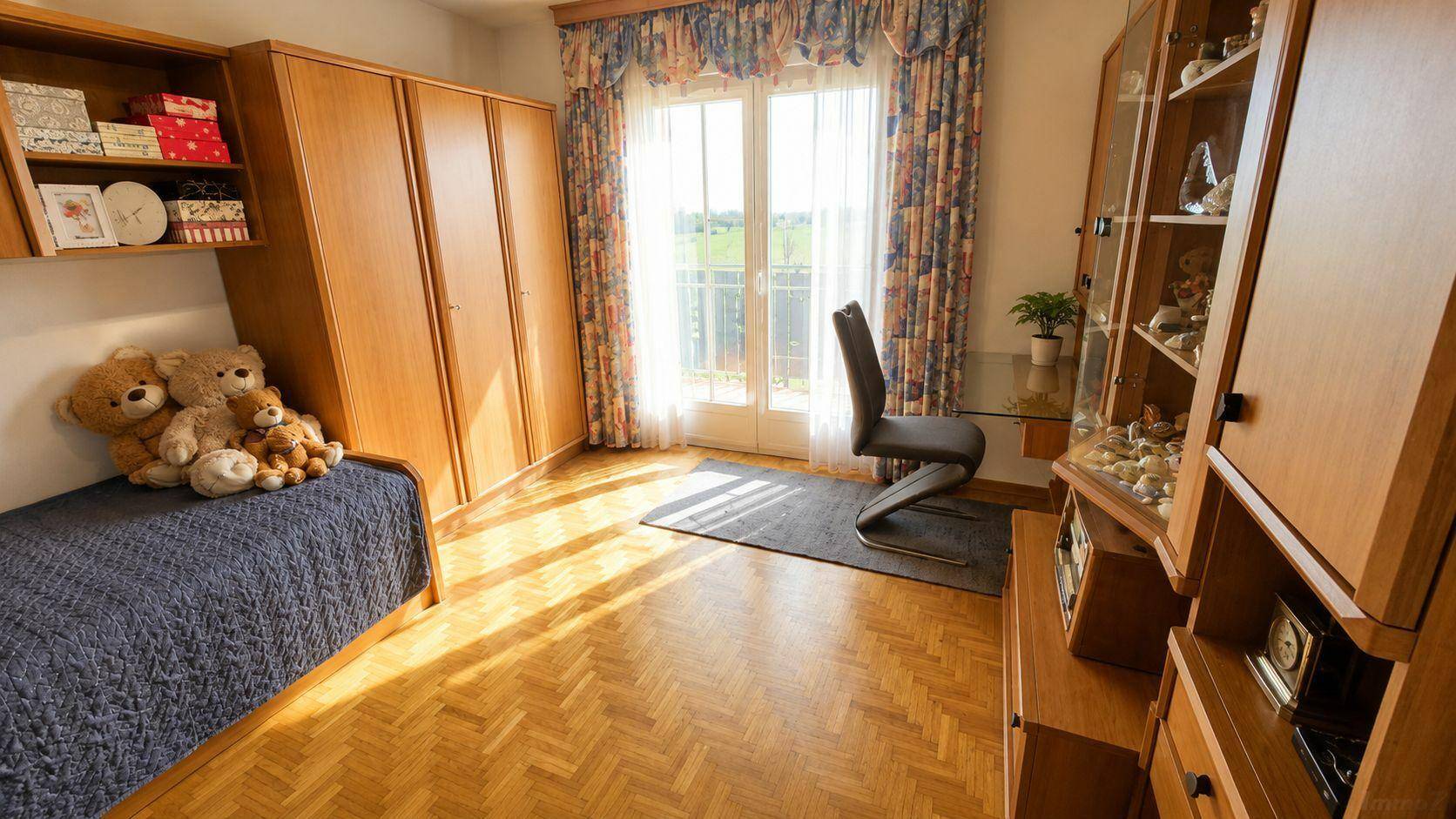Helles Schlafzimmer mit Holzparkett, Kleiderschrank und Zugang zu einem französischen Balkon.