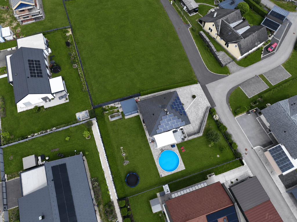 Vogelperspektive des Hauses mit Photovoltaikanlage, Pool und gepflegtem Gartenbereich.