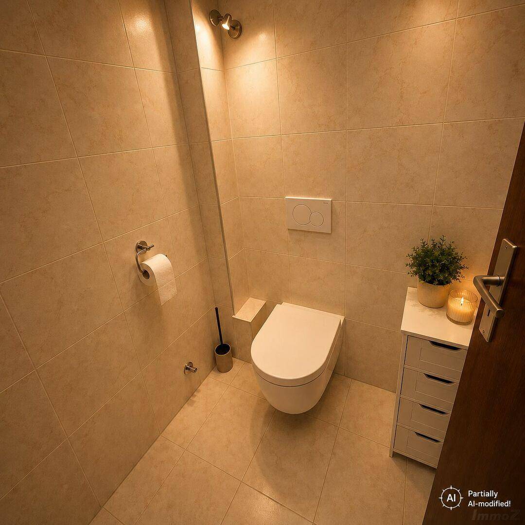 Kleines Gäste-WC mit wandhängender Toilette, beigefarbenen Fliesen und indirekter Beleuchtung.