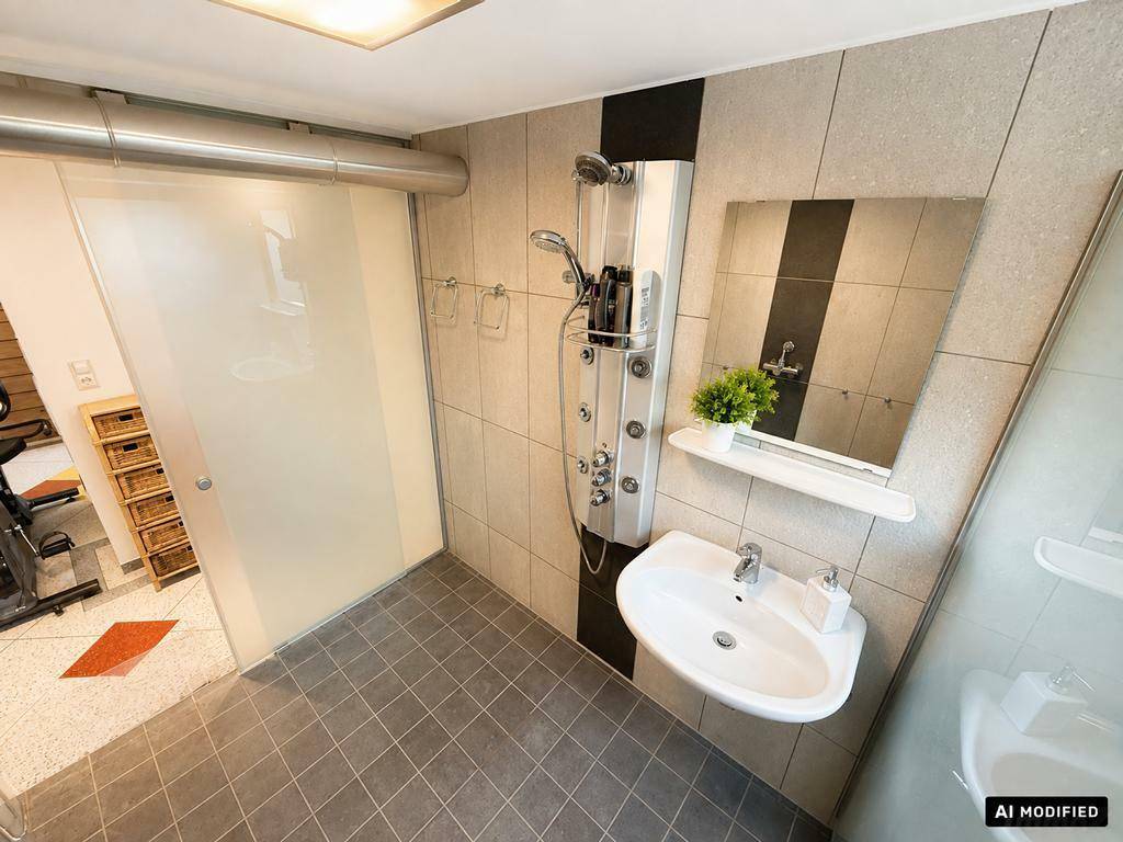 Modernes Badezimmer mit Duschkabine, Waschbecken und hellen Fliesen.