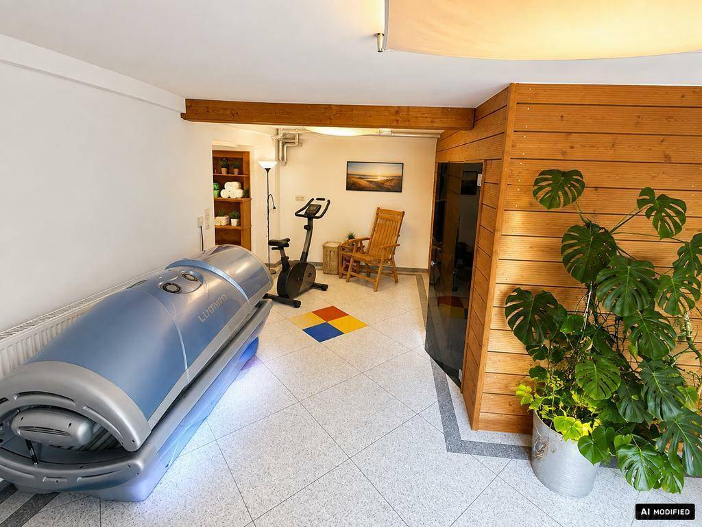 Wellnessbereich mit Solarium, Heimtrainer und Fliesenboden.